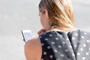Millennial woman using her mobile phone to browse social media sites
