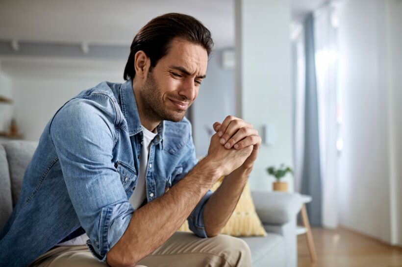 Young sad man crying at home.