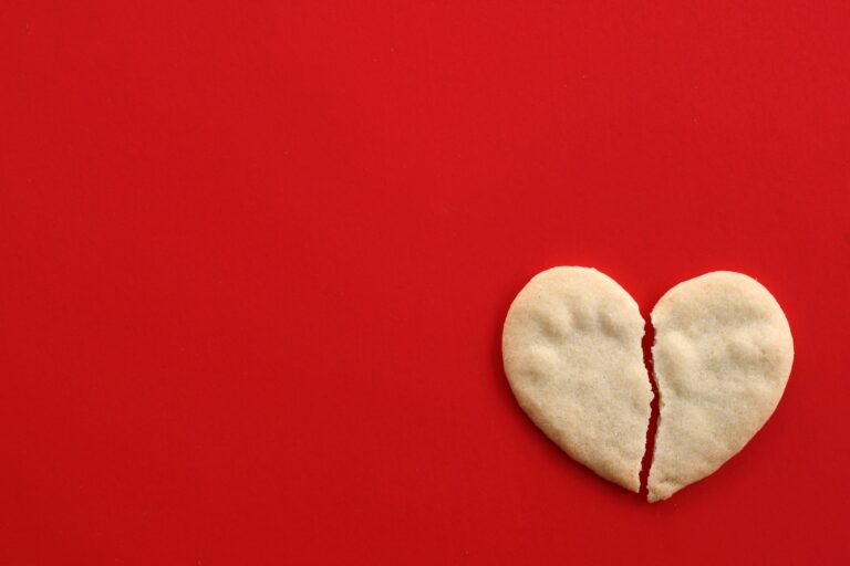 Hogyan találhatod meg önmagad egy szakítás után? Broken heart cookie on red - concept breaking up, divorce, ending relationship, brokenhearted