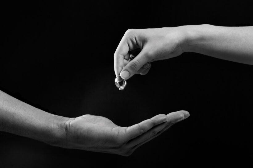 couples hands breaking up - wedding ring