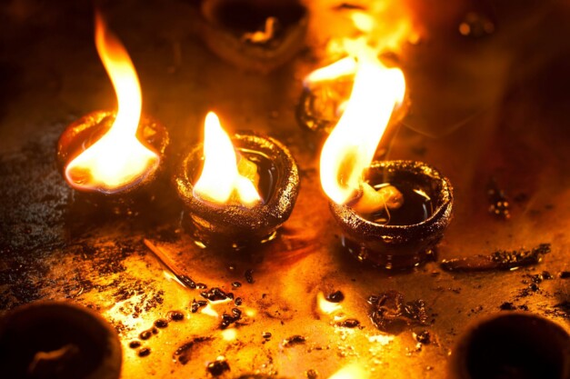 Burning oil lamps at religious temple. India