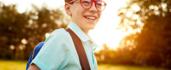 Cheerful schoolboy in park in evening