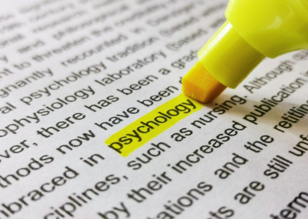 Close-up image of marker highlighting word psychology in book.