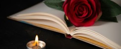 front view of burning candle with open book on dark background tank death