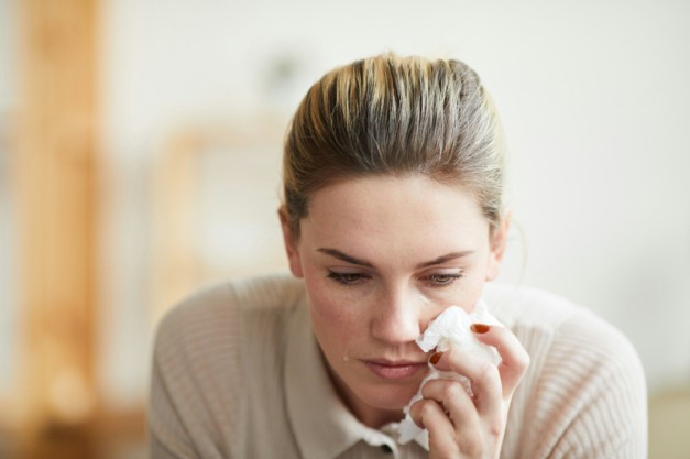 Grief-stricken woman wiping tears