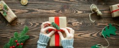 Hands decorating a Christmas gift box