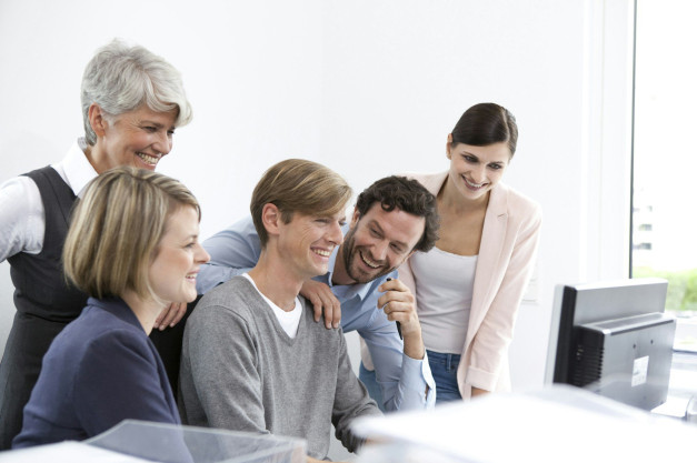 Happy business team at desk in office