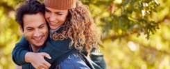 Happy Loving Couple Smiling As Man Give Woman Piggyback In Autumn Park