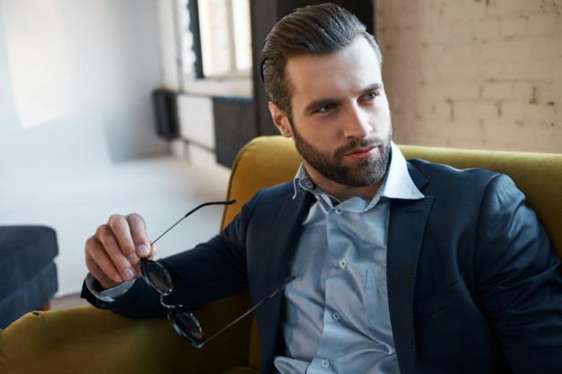 In search of inspiration. Thoughtful handsome businessman is holding glasses and thinking about