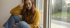 Sad woman drinking wine. Young redhead woman drinking wine at home