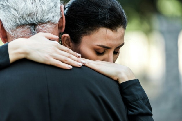 selective focus of woman hugging senior man