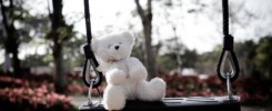 Teddy Bear sitting on Swing, Symbols Violence Domestic Abuse Sad grief