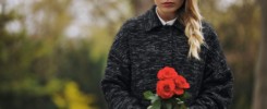 Young woman at graveyard with fresh roses